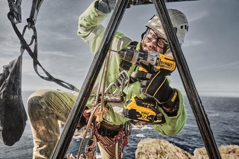 DEWALT DCD996P2, DCD996P2-QW Bohrmaschine draußen im Einsatz; Meer und Felsen im Hintergrund. Kategorie Fotografie.