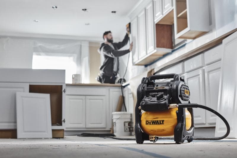 DEWALT Akku-Kompressor bei Küchenrenovierung, ein Arbeiter verwendet Elektrowerkzeuge.